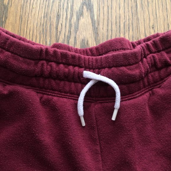 These are red sweatpants with two gold stripes. - Picture 4 of 4